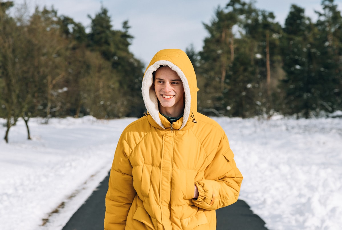 Pessoa com anoraque amarelo em caminho nevado, vista da escotilha